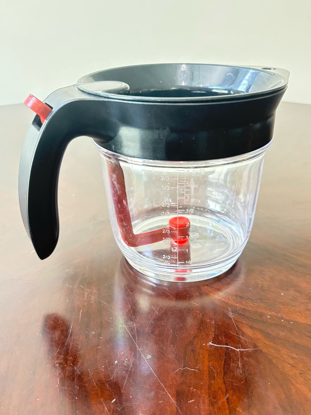 Clear Glass Measuring Pitcher with Black Lid and Red Stirring Arm